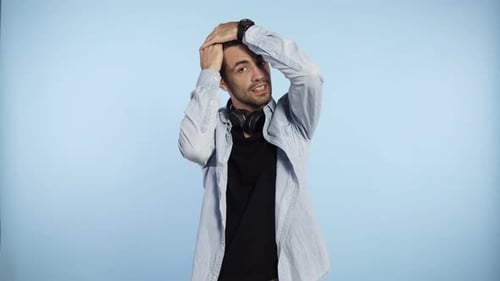 Man Styles Hair in Studio with Headphones