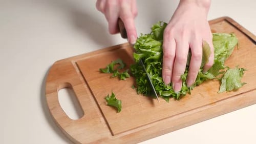 Hands Chopping Lettuce on a Cutting Board