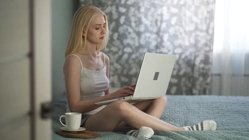 Woman Work on Laptop Computer and Sit on Bed