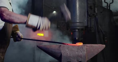 Blacksmith Shaping Hot Metal with Hammer and Anvil