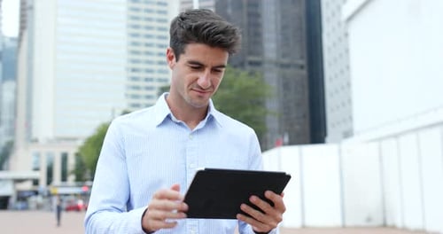 Un homme hispanique utilise une tablette numérique en ville