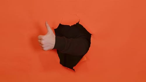 Hand Giving Thumbs Up Through Orange Paper