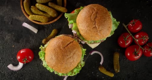 Appetizing Burgers Displayed With Tomatoes and Pickles