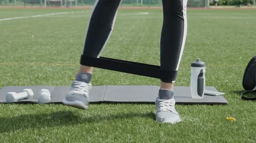 Woman Exercising with Resistance Band in Park