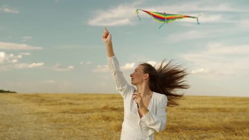 Woman Flies Kite in Sunny Rural Field