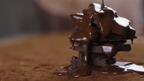 Melting Chocolate Drizzled onto Stack of Dark Chocolate