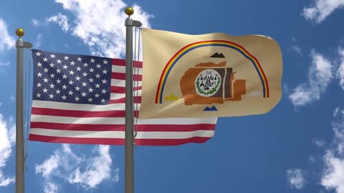 United States and Navajo Nation Flags Waving Against Blue Sky