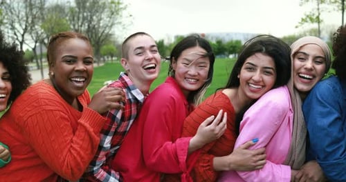Young multiracial women having fun laughing together at city park - Diversity concept