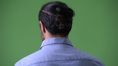 Profile View of Young Handsome Bearded Indian Businessman Looking Back