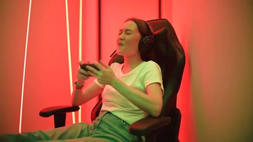 Woman Playing Game on Mobile Phone in Gaming Chair