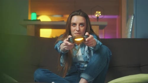Woman Playing Video Game on Couch Wins and Celebrates