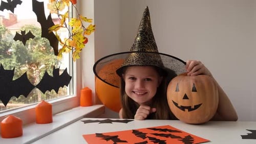 Child Poses With Halloween Pumpkin Decorations
