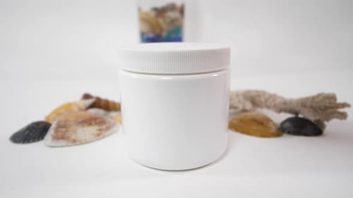 White Jar with Lid Surrounded by Seashells