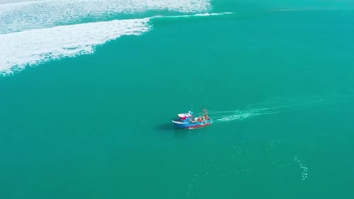 Fishing Boat Floating on Ocean Waves Near Shore