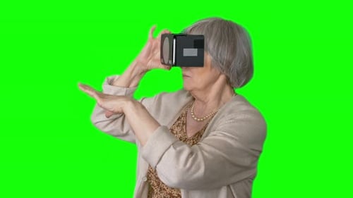 Senior Woman Experiencing Virtual Reality Headset on Green Screen