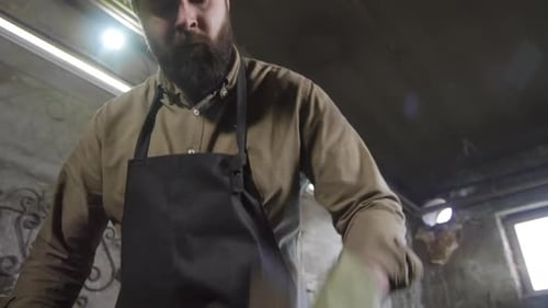 Blacksmith Hammering Metal on Anvil in Workshop