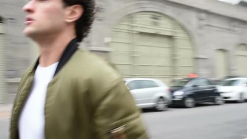 Slow motion young beautiful man running outdoor city street