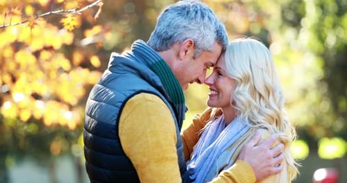 Loving Couple Embracing in a Park in Autumn