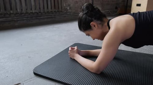 Close - up of a Sporty Young Indian Woman in a Black Top and Leggings Doing a Plank Exercise