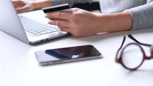 Woman Makes Online Payment at Home with a Credit Card and Laptop