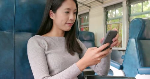 Femme regardant son téléphone portable et prenant le train