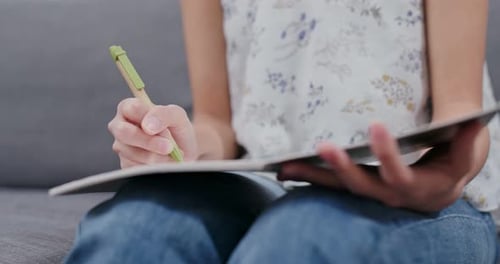 Woman take note on notebook at home