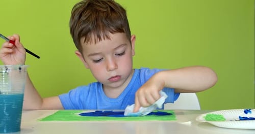 Child Painting a Picture Indoors