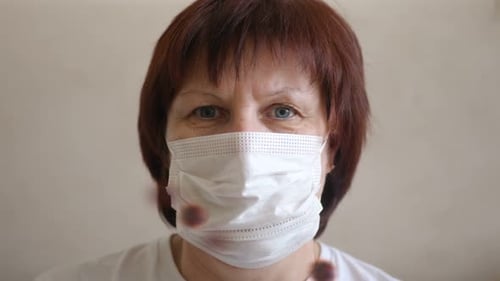 Frau setzt chirurgische Maske zur Vorbeugung von Coronaviren auf.