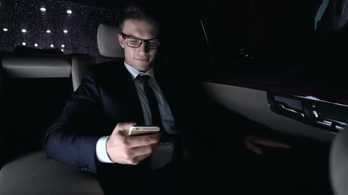 Male in Suit Texting With Girlfriend on Back Seat of Car as Driving Home, Flirt