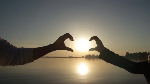 Las manos de hombres y mujeres muestran el símbolo de un corazón