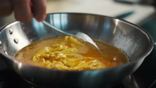 Professional restaurant kitchen, close-up: the process of cooking an omelette in a frying pan