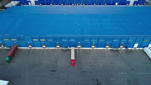Aerial Top View of the Large Logistics Park with Warehouse with Some Semi-trailers Trucks.
