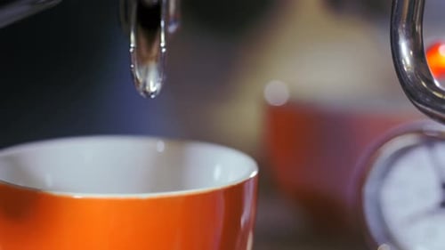 Espresso Pouring into Orange Coffee Cup