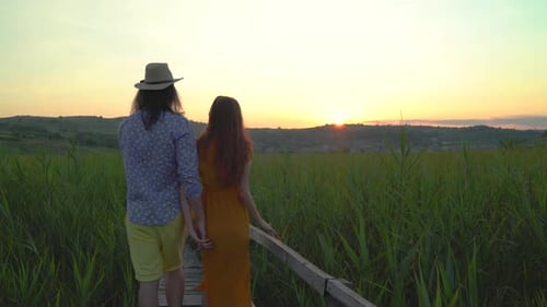 Paar spaziert bei Sonnenuntergang in einem Schilffeld