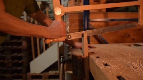 Carpenter Sawing Wood By Hand in His Workshop