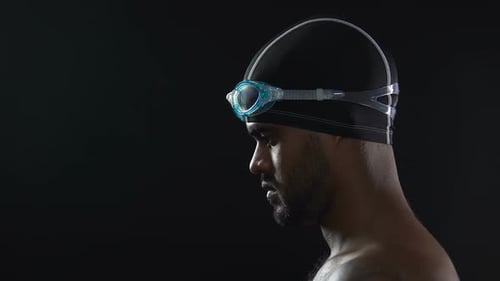 Closeup of Male Athlete Wearing Goggles and Preparing to Jump Into Swimming Pool