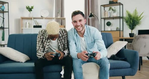 Friends Play Video Games Together on Couch