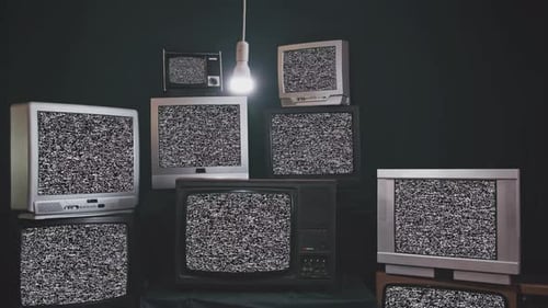 Nine Vintage Televisions Turning on Green Screens on a Retro TV Wall