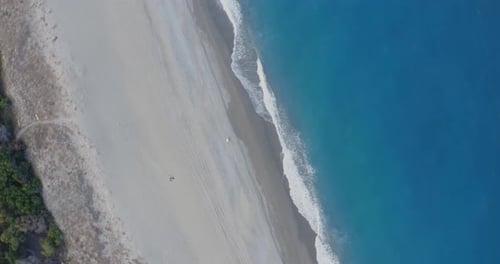 Vista aérea de las olas rompiendo en la playa de arena