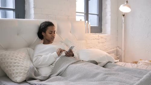 Woman Relaxing in Bed Using Smartphone