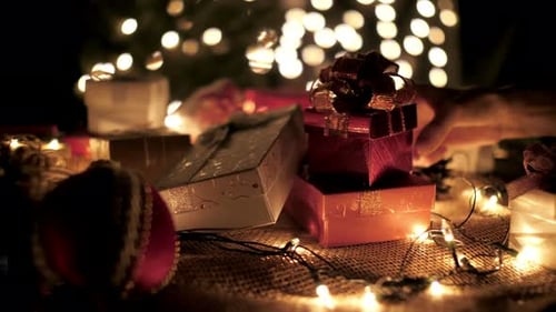 Arranging Christmas Gifts under Glowing Tree