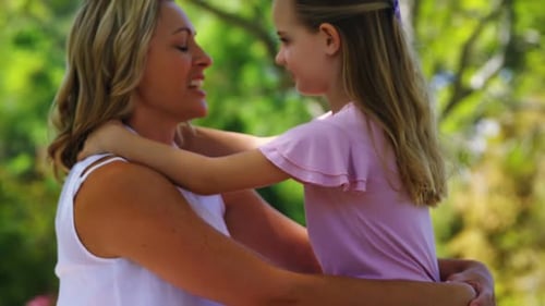 Happy mother embracing her daughter in park 4k