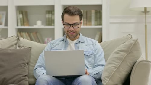 Man Video Chatting on Laptop at Home