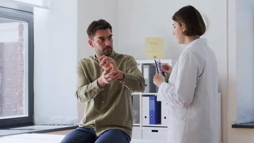 Man Patient Showing Sore Arm to Doctor at Hospital