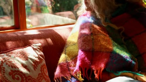 Mature woman looking through window at home