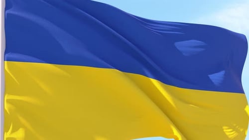 Waving Flag of Ukraine Against Blue Sky