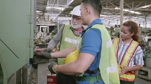 Factory Workers Discussing Machine Operation Indoors