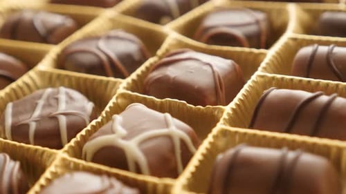 Tilting over gift set of many different candies 4K 2160p 30fps UltraHD footage - Assorted chocolate