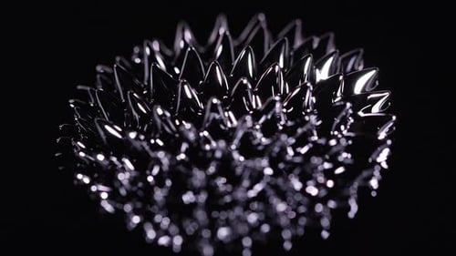 Glossy Black Liquid Forming Spiky Patterns on Black