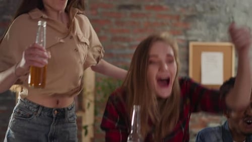 Des femmes excitées Clink Bottles célèbrent leur victoire avec leurs amis